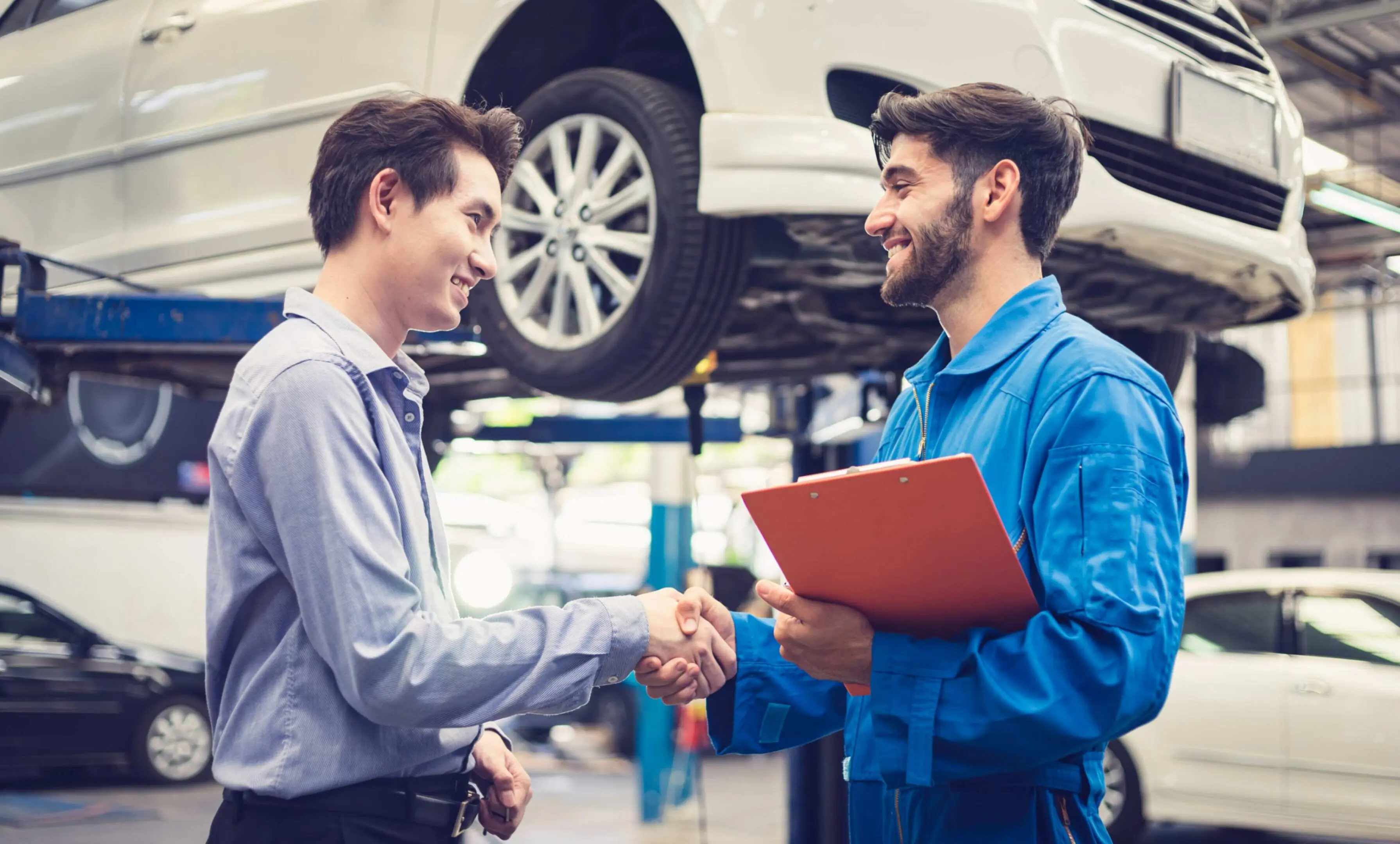 jpeg-optimizer_GettyImages-1210893897 Mechanic and customer shaking hands in garage.