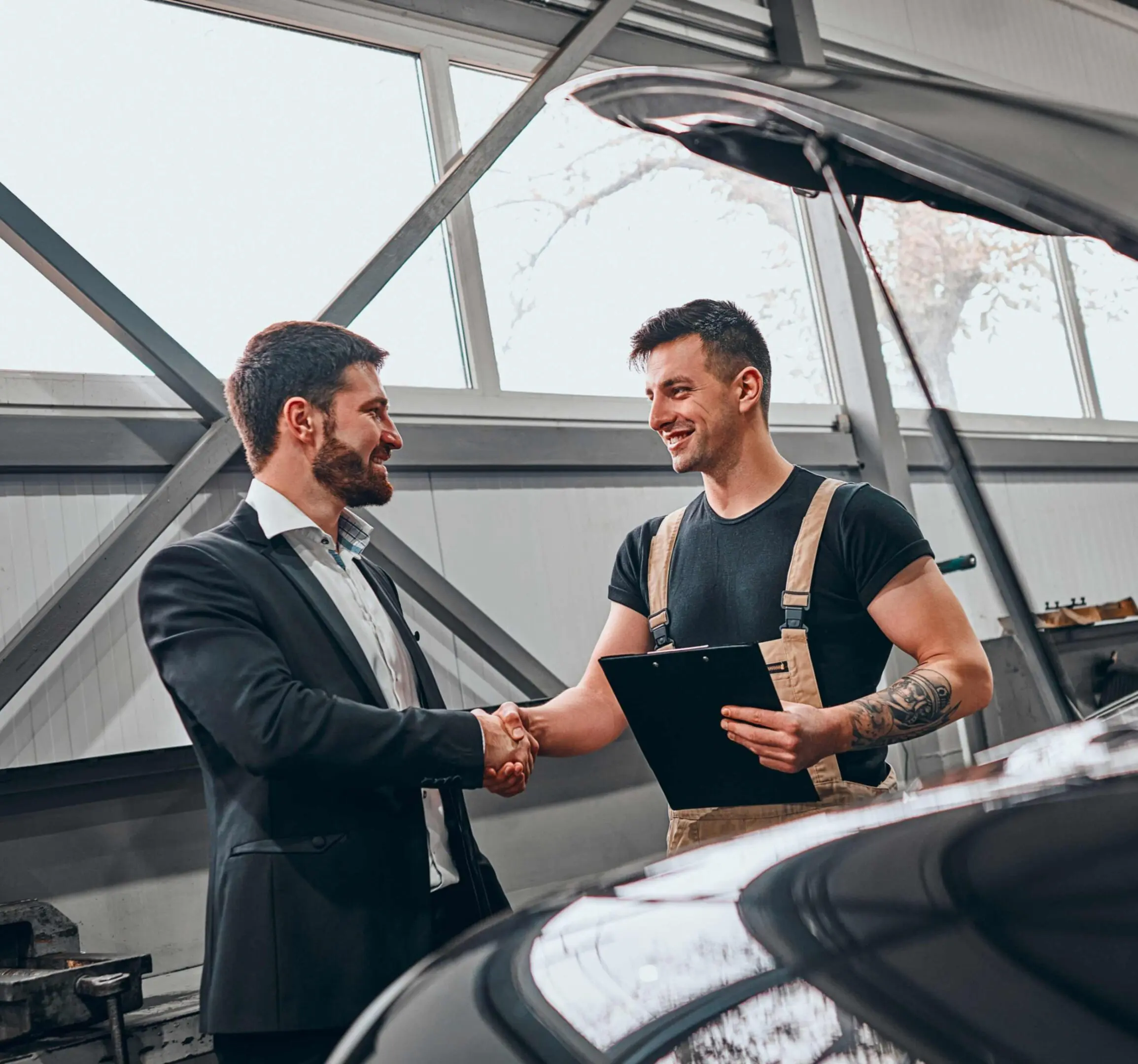 jpeg-optimizer_GettyImages-1301650307 Mechanic and businessman shaking hands in garage.