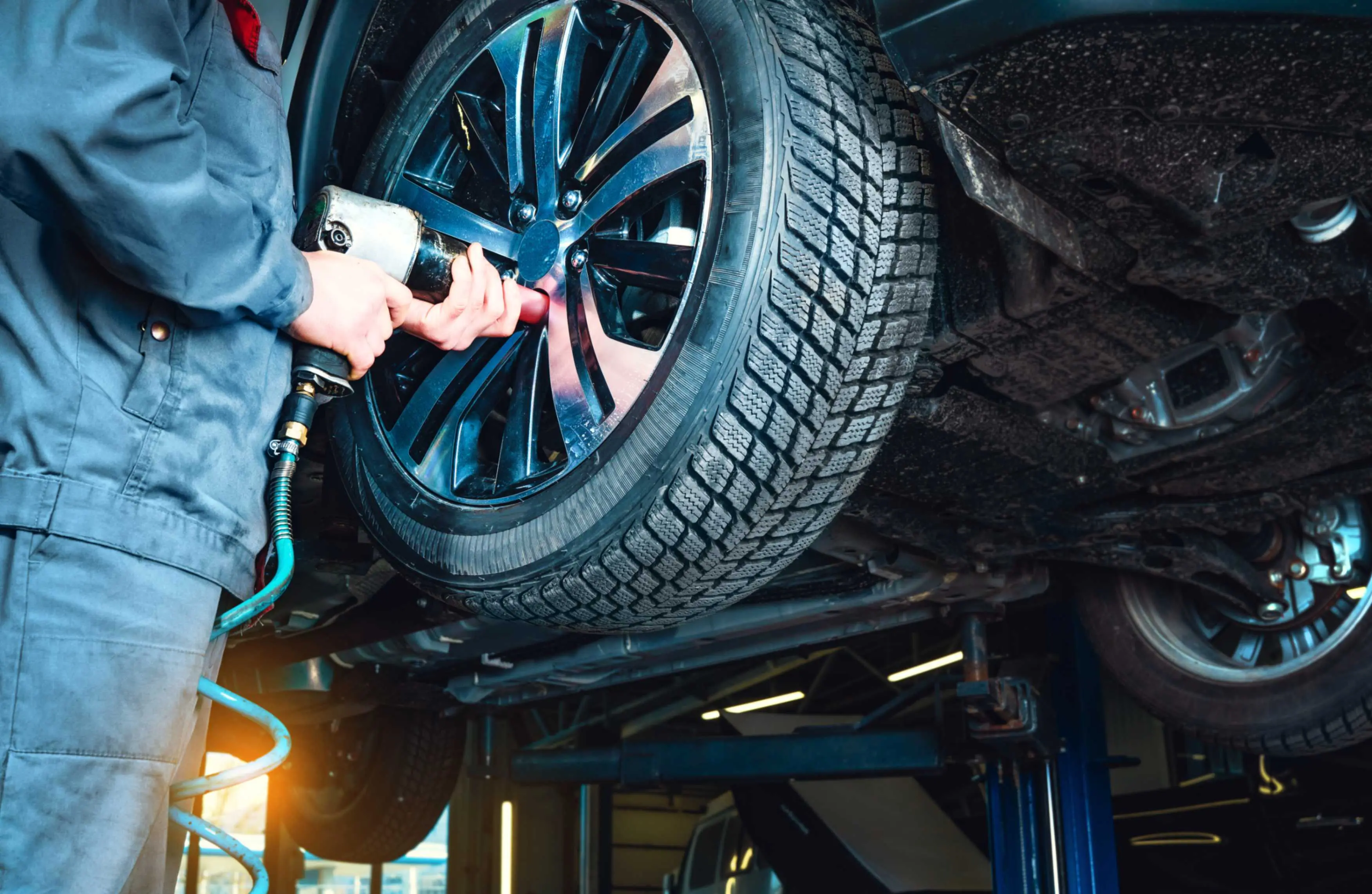 jpeg-optimizer_GettyImages-1363564568 Mechanic tightening car wheel with tool.